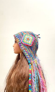 a doll with long hair wearing a multicolored knitted hat on top of it's head