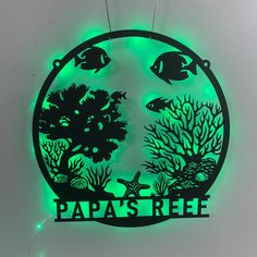 a neon sign that reads papa's reef with fish and corals on it