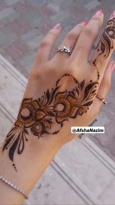 a woman's hand with henna tattoos on it