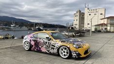 a yellow sports car parked in front of a body of water