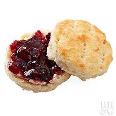 two biscuits with jam on them sitting next to each other