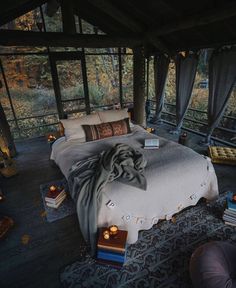 an image of a bed in the middle of a room that is decorated with candles