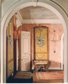 an archway leading into a living room with paintings on the wall and rug in front of it