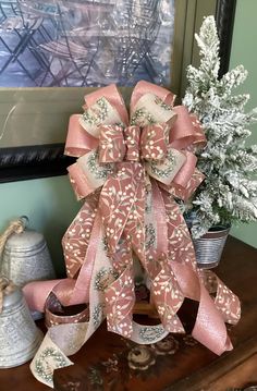 a pink bow sitting on top of a wooden table next to a potted plant