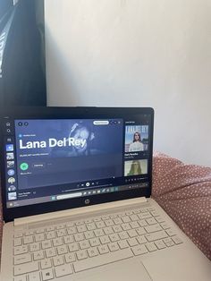 an open laptop computer sitting on top of a bed