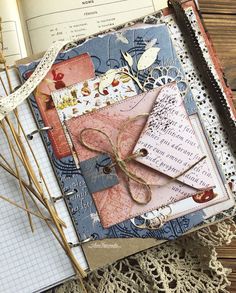 an open book sitting on top of a wooden table next to a pile of papers