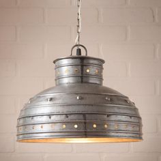 an industrial style light fixture hanging from a brick wall