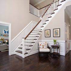 a white staircase in a house with hardwood floors and hard wood flooring on the ground