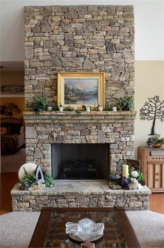 a living room with a stone fireplace and mantle