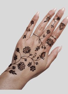 a woman's hand with tattoos on it and flowers painted on the palm area