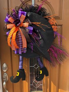 a door decorated for halloween with a witch's hat and broom