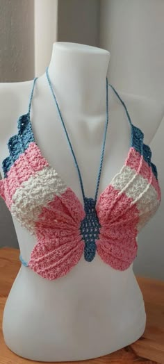 a white mannequin wearing a pink, blue and white crochet bra