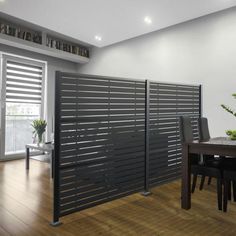 a room divider in the middle of a wooden floor with chairs and a table