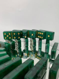 several pieces of green glass with gold dots on the edges and sides, sitting in front of a white background