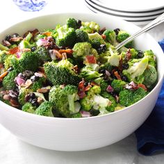 a white bowl filled with broccoli and raisins on top of a table