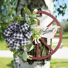 a peace sign is attached to a tree with a bow on it's head