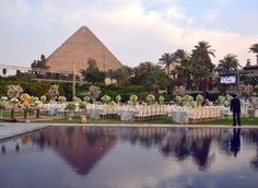 an outdoor wedding set up in front of the pyramid