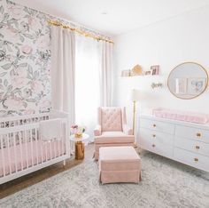 a baby's room with pink furniture and floral wallpaper