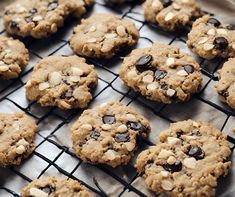 chocolate chip cookies cooling on a rack with some almonds in the middle and one cookie half eaten