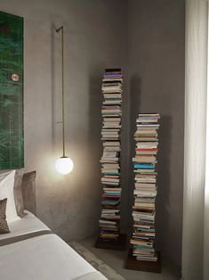 a room with a bed, lamp and bookshelf on the wall next to it