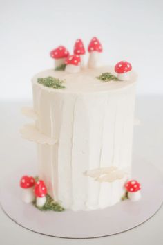 a white cake with red mushrooms on it