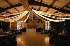 a large room with white drapes and chandeliers