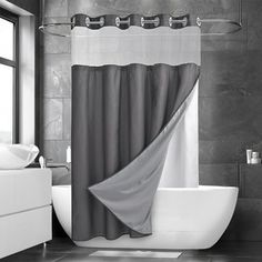 a bathroom with a tub, sink and shower curtain in black and white color scheme