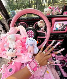 a person with pink nail polish on their nails in a car filled with stuffed animals