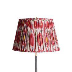 a red and white lamp with a pink shade on the bottom, sitting on a metal base