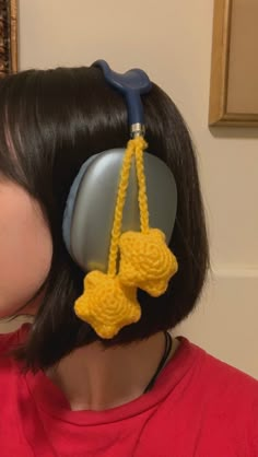 a woman wearing ear muffs made out of crocheted yarn and attached to a hair dryer