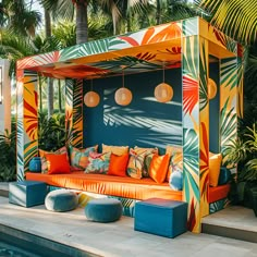 an outdoor seating area next to a swimming pool with palm trees in the back ground