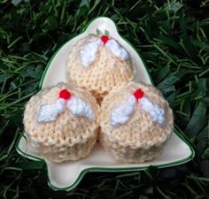 three crocheted cupcakes sitting on top of a plate in the grass