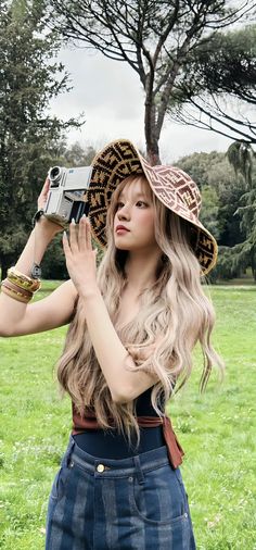 a woman with long hair wearing a hat and holding a camera