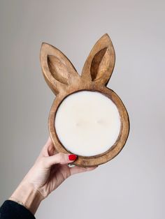 a person holding a candle in front of their face shaped like an animal's head