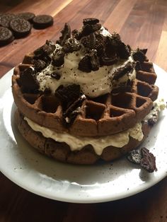 a waffle topped with ice cream and oreo cookies on top of a white plate