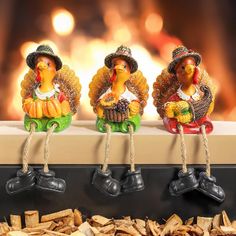 three ceramic turkey figurines sitting on top of a shelf next to wood chips