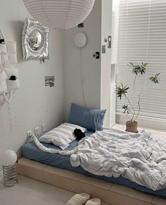 a bedroom with white walls and blue bedding