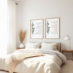 a bed with two framed pictures above it in a white room next to a window