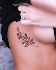 a woman with a rose tattoo on her back is looking down at her lower body