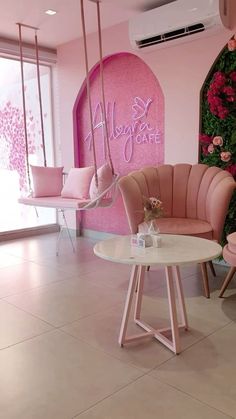 a room with pink furniture and flowers on the wall, in front of a sign that says happy girl