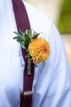 a boutonniere with an orange flower on it