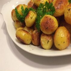 a white plate topped with potatoes covered in parsley