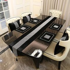 a black and white dining table with chairs around it in the middle of a room