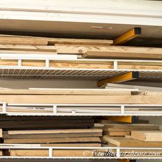 the shelves are filled with various types of wooden planks and plywood boards for storage