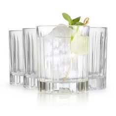 three glasses filled with ice and limes on top of each other in front of a white background