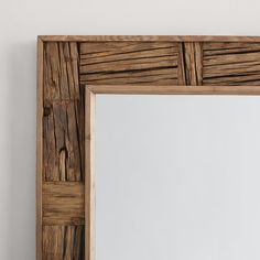 a wooden frame mirror hanging on the wall