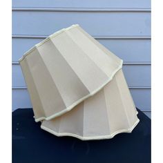 a lamp shade sitting on top of a table next to a blue wall with white trim