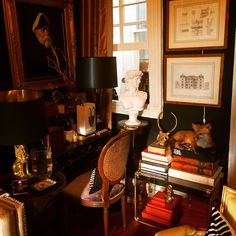 a living room filled with lots of furniture and pictures on the wall next to a window