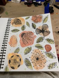 an open notebook with watercolor drawings on it