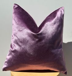 a purple pillow sitting on top of a wooden table